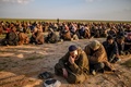 IS最後の拠点、シリア東部バグズを離れ、シリア民主軍（SDF）による尋問を待つIS戦闘員とみられる男たち（2019年2月22日撮影）。(c)AFP / Bulent Kilic