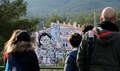 スペインのカステリョンデラプラナ近郊の町ファンサラにある家の壁に描かれた作品を鑑賞する人々（2016年12月15日撮影）。(c)AFP/JOSE JORDAN