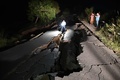 パキスタン・ミルプール近郊で、地震により損壊した道路を撮影する報道関係者（2019年9月24日撮影）。(c)AAMIR QURESHI / AFP