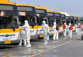 韓国・光州のバス車庫で消毒作業をする政府当局者ら（2020年3月3日撮影）。(c)YONHAP / AFP