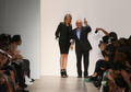 米・ニューヨーク市内で発表されたエルベ・レジェ バイ マックスアズリア（Herve Leger By Max Azria）の10年春夏コレクションのフィナーレに登場したデザイナーのマックスアズリア（右、2009年9月13日撮影）。(c)AFP/Getty Images/Kristian Dowling