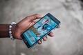 ナイジェリア・ラゴスで、歩きながらのプレーに注意を促す「ポケモンGO」の画面が表示された携帯電話（2016年7月14日撮影）。(c)AFP/STEFAN HEUNIS
