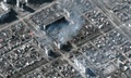 ウクライナ南東部マリウポリで、破壊され煙を上げる集合住宅を捉えた衛星写真。マクサー・テクノロジーズ提供（2022年3月22日撮影、公開）。(c)AFP PHOTO / Satellite image ©2022 Maxar Technologies 