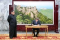 韓国・北朝鮮間の非武装地帯（DMZ）にある板門店で、芳名録に記入する韓国の文在寅大統領（右）と北朝鮮の金正恩労働党委員長。韓国大統領府が公開（2018年5月26日撮影、27日公開）。(c)AFP PHOTO / THE BLUE HOUSE