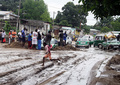 コンゴ共和国の首都ブラザビル（Brazzaville）南部を襲った集中豪雨で住宅数十棟が倒壊し、10日の当局の発表によると、少なくとも13人が死亡、26人が負傷した。

赤十字（Red Cross）では、被災地で13人の遺体が発見されたと発表した。また、ブラザビル南部のマケレケレ（Makelekele）地区の区長は報道陣に対し、少なくとも26人が負傷したと語った。

目撃者によると、メケレケレの近くに流れている川の土手が決壊し、数十棟もの家屋が倒壊したという。

現地警察は死者数が発表通りであることを認め、洪水で被災した600人近い住民のために避難所を設けたと発表した。

写真は洪水の被害で溝ができた道路を飛び越える少年（手前、2012年12月10日撮影）。(c)AFP/GUY GERVAIS KITINA