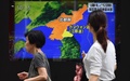 北朝鮮による飛翔体発射について報じるテレビの画面を見つめる歩行者。都内にて（2019年8月16日撮影）。(c)Kazuhiro NOGI / AFP