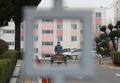 韓国・大邱で、封鎖された複合住宅内を防護服を着用して歩く保健当局者（2020年3月7日撮影）。(c)YONHAP/AFP