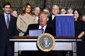 国防権限法に署名するドナルド・トランプ大統領と、後ろで見守る（前から2列目左から）マーク・エスパー米国防長官、メラニア夫人、マイク・ペンス副大統領、カレン夫人（2019年12月20日撮影）。(c)Nicholas Kamm / AFP