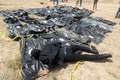 イラク・ティクリートのスペイサー軍事基地に横たえられた、ISに殺害されたとみられる人々の遺体に寄り添う男性（2015年4月12日撮影）。(c)AFP / Ahmad Al-Rubaye