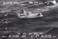 米ハワイ沖で、パラシュートを使って海上に不時着した小型機から出て救命ボートに乗り込んだ操縦士。米沿岸警備隊公開の映像より（2015年1月26日提供）。(c)AFP/HANDOUT/US COAST GUARD