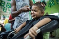 ブラジル・リオデジャネイロ（Rio de Janeiro）の理髪店で髪を切られる少年（2014年6月27日撮影）。(c)AFP/YASUYOSHI CHIBA