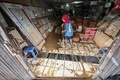 豪雨による洪水に見舞われたインドネシアの首都ジャカルタで、泥がたまった店舗を清掃する女性（2020年1月3日撮影）。(c)BAY ISMOYO / AFP