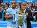 13-14イングランド・プレミアリーグ最終第38節、マンチェスター・シティ（Manchester City）対ウェストハム（West Ham）。トロフィーを手にカメラに向けポーズを取るマンチェスター・シティのヴィンセント・コンパニー（Vincent Kompany、左）とマヌエル・ペジェグリーニ（Manuel Pellegrini）監督（2014年5月11日撮影）。(c)AFP/ANDREW YATES
