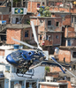 ブラジル・リオデジャネイロ（Rio de Janeiro）北部のスラム街で行われた麻薬組織の制圧作戦で、上空を飛ぶ軍ヘリ（2010年11月28日撮影）。(c)AFP/Antonio Scorza