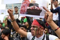 ベルギーの首都ブリュッセルで行われたタリバンのアフガニスタン制圧に抗議するデモで、アシュラフ・ガニ大統領の写真を掲げる人（2021年8月18日撮影）。(c)JOHN THYS / AFP