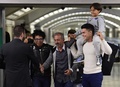 スペインの首都マドリードの駅に息子2人と共に到着し、サッカーのコーチ養成学校の学長（左）と握手する、シリア難民のオサマ・アブドル・モフセンさん（中央、2015年9月16日撮影）。AFP/JAVIER SORIANO