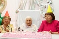 南アフリカ・タウズリバーの老人ホームで、118歳の誕生日を迎えたマーガレット・マリッツさん（中央）。両脇は娘（2024年9月27日撮影）。(c)RODGER BOSCH / AFP