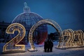 ロシア首都モスクワで、クリスマスと新年を祝うイルミネーションの前で写真を撮る家族（2022年12月19日撮影）。(c)Natalia KOLESNIKOVA / AFP