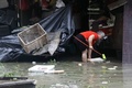 台風14号が上陸した中国・福建省のアモイで、冠水し物品が散乱する通りを片付ける住民たち（2016年9月15日撮影）。(c)AFP