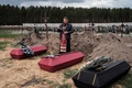 ウクライナ・ブチャで、死亡した3人の葬儀を執り行う司祭（2022年4月18日撮影）。(c)Yasuyoshi CHIBA / AFP