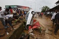 コートジボワールのアビジャンで、車の残骸を見つめる人々（2018年6月19日撮影）。(c)AFP PHOTO / Sia KAMBOU