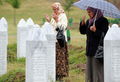 ボスニア・ヘルツェゴビナ東部スレブレニツァ（Srebrenica）の郊外ポトチャリ（Potocari）のスレブレニツァ虐殺犠牲者追悼施設で、親族の墓前で祈るイスラム教徒女性（2008年7月22日撮影）。(c)AFP/ELVIS BARUKCIC