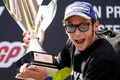 世界ロードレース選手権、第7戦スペインGPでMotoGPクラス決勝を制し、トロフィーを掲げるモビスター・ヤマハのバレンティーノ・ロッシ（2016年6月5日撮影）。(c)AFP/JOSEP LAGO