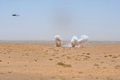アフガニスタン南部ヘルマンド（Helmand）州ガルムシール（Garmsir）地区で、麻薬撲滅作戦のパフォーマンスとして、ヘリコプターから爆発物が投下され燃やされるケシの種の山（2009年7月21日撮影）。(c)AFP/SHAH MARAI