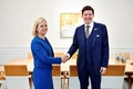 スウェーデンの首都ストックホルムで、アンドリアス・ノルリアン議会議長（右）と握手するマグダレナ・アンデション財務相（2021年11月11日撮影）。(c)Jessica GOW / TT News Agency / AFP
