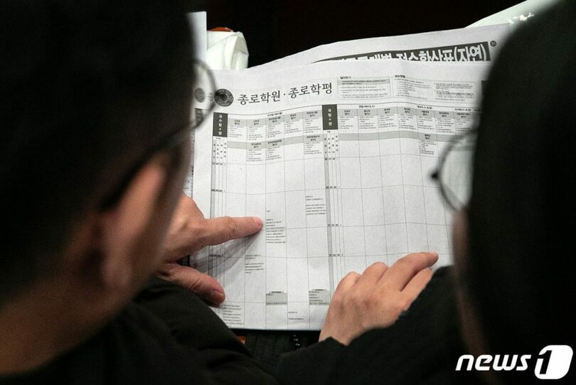 定時募集配置参考表を見る保護者ら(c)news1