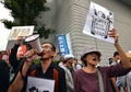 横浜市で開かれた安全保障関連法案に関する地方公聴会の会場前でプラカードを掲げて同法案に抗議する人々（2015年9月16日撮影）。(c)AFP/Yoshikazu TSUNO