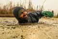 インド・スリナガルのアンチャー湖で、氷点下の寒さのなか冷たい水に漬かってハスの茎を収穫するカシミールの農家の人（2022年11月30日撮影）。(c)TAUSEEF MUSTAFA / AFP