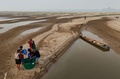 ブラジル北部アマゾナス州ウマイタを流れるマデイラ川の砂州に沿って飲み水を運ぶ人々（2024年9月7日撮影）。(c)MICHAEL DANTAS / AFP