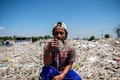 インドネシア・バングンのごみ集積所に座るクマンさん（2019年7月22日撮影）。(c)Juni Kriswanto / AFP