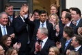 英ロンドンの保守党本部に到着し、拍手で迎えられるリシ・スナク次期首相（中央、2022年10月24日撮影）。(c)Daniel LEAL / AFP