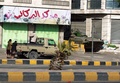 イエメンの首都サヌア（Sanaa）で、アブドラボ・マンスール・ハディ（Abdrabuh Mansur Hadi）大統領の私邸近くを警備する戦車と護衛隊（2015年1月21日撮影）。(c)AFP/MOHAMMED HUWAIS