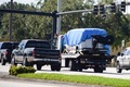 米フロリダ州プランテーションで、不審小包郵送事件との関連で、青い防水シートをかけられ米連邦捜査局（FBI）捜査班にけん引されるバン（2018年10月26日撮影）。(c)Eric BARADAT and Michele Eve Sandberg / AFP