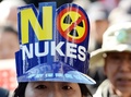 脱原発のスローガン入りの帽子をかぶって都内で行われたデモ行進に参加した人（2014年3月15日撮影）。(c)AFP/TOSHIFUMI KITAMURA