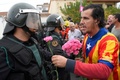 スペイン・カタルーニャ自治州サント・ジュリア・デ・ラミスの投票所の外で、治安警察隊員にカーネーションを手渡そうとする男性（2017年10月1日撮影）。(c)AFP/LLUIS GENE