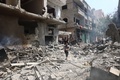 パレスチナ自治区ガザ地区中部ヌセイラットの難民キャンプで、イスラエル軍の攻撃で損傷した建物のがれきの中を走る男性（2024年6月8日撮影）。(c) Eyad BABA / AFP