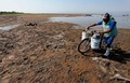 メキシコ・ハリスコ州のチャパラ湖で、元の湖岸から約200メートル離れた場所に船を止め魚を運ぶ漁師（2024年6月6日撮影）。(c)Ulises Ruiz / AFP