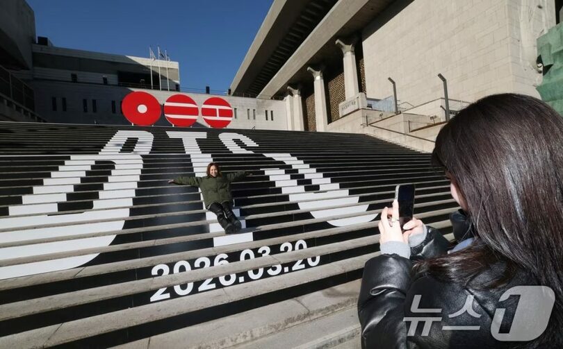 ソウル市鍾路区の世宗文化会館前に設置されたBTSのカムバックロゴの前で記念撮影する観光客(c)news1