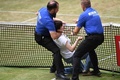 男子テニス、テラ・ウォルトマン・オープン、シングルス決勝。コートに侵入し、警備員に取り押さえられる女（2022年6月19日撮影）。(c)Carmen JASPERSEN/ AFP