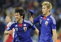 2010年サッカーW杯南アフリカ大会（%%2010 World Cup%%）1次リーグE組、デンマーク対日本。日本は3-1で勝利し、勝ち点6（2勝1敗）の同組2位で決勝トーナメントに進んだ。日本の決勝トーナメント進出は、自国開催以外のW杯では初めて。写真は後半42分にチームの3点目を決め、本田圭佑（%%Keisuke Honda%%）と喜ぶ日本の岡崎慎司（%%Shinji Okazaki%%、左）。（2010年6月24日撮影）(c)AFP/STEPHANE DE SAKUTIN