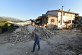 大地震に見舞われたイタリア・アマトリーチェ近郊のサンロレンツォで、損壊した住宅のそばを歩く男性（2016年8月27日撮影）。(c)AFP/ALBERTO PIZZOLI