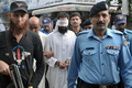 パキスタン・イスラマバード（Islamabad）の裁判所に警察官に付き添われて出廷するハフィーズ・ムハンマド・ハリード・チシュティ（Hafiz Mohammed Khalid Chishti）容疑者（中央の白い目隠しをされている人物、2012年9月2日撮影）。(c)AFP/Farooq NAEEM