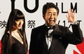 第26回東京国際映画祭（Tokyo International Film Festival）のオープニングイベントに登場した安倍晋三（Shinzo Abe）首相（右）と映画祭のフェスティバル・ミューズを務める栗山千明（Chiaki Kuriyama、2013年10月17日撮影）。(c)AFP/TOSHIFUMI KITAMURA