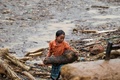 ベトナム北部イエンバイ省の山間部の鉄砲水に襲われた町で、流木を集める少女（2017年8月5日撮影）。(c)AFP