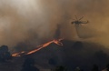 米カリフォルニア（California）州ロサンゼルス（Los Angeles）市郊外カラバサス（Calabasas）で18日、高速道路101号線付近で山火事が発生し、ロサンゼルス郡消防当局によるとこれまでに16～20ヘクタールが焼けた。火事の原因は北行きの車線で起きた自動車火災だとされ、消防当局が地上と空から消火活動にあたっている。

写真は、延焼する山火事と消火にあたるヘリコプター（2013年8月18日撮影）。(c)AFP/JOE KLAMAR