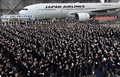 都内の羽田空港で行われた日本航空（JAL）グループの入社式で、紙飛行機を飛ばす新入社員ら（2016年4月1日撮影）。(c)AFP/KAZUHIRO NOGI